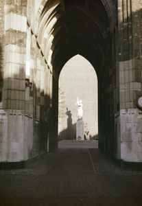 831840 Gezicht op de onderdoorgang van de Domtoren te Utrecht met op de achtergrond het Verzetsmonument op het Domplein.